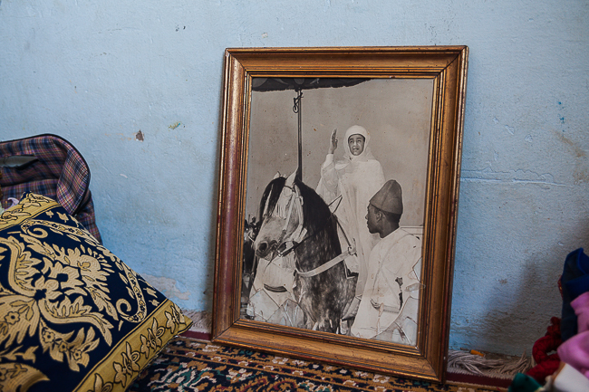 A framed portrait of the late King Hassan II riding an Arabian horse rests against the wall in Bouchra’s room.
