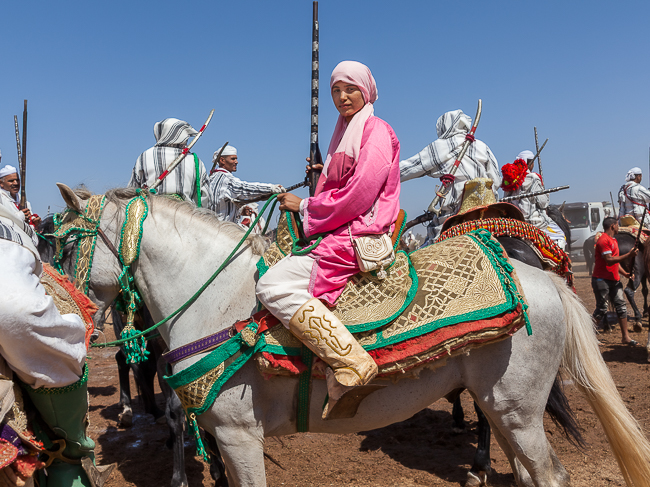 A rider from the all-female Farisat Al Hawzia troupe moves through a gathering of male Tbourida riders.