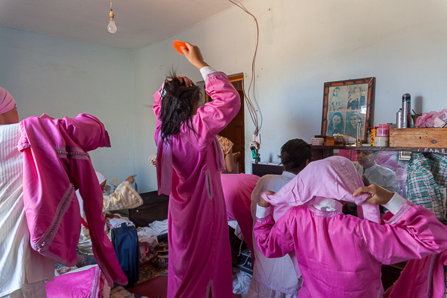 préparatifs avant la Fantasia, la tenue est réglementaire ; une longue tunique, un turban ou foulard pour  couvrir les cheveux, des bottillons blancs ou noirs et un pantalon. Contrairement aux hommes, les femmes ont le droit de mettre des couleurs vives pour être distinguées lors de la Fantasia. Preparations before the Fantasia, the appearance is regulatory; a long tunic, a turban or a scarf to cover hair, white or black bootees and pants. Unlike men, women have the right to wear bright colors to be distinguished during the Fantasia.